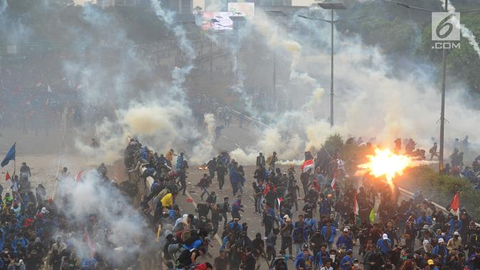 Mahasiswa berlarian saat polisi menembakkan gas air mata dalam demonstrasi menolak pengesahan RUU KUHP dan revisi UU KPK di depan Gedung DPR, Jakarta, Selasa (24/9/2019). Polisi menghalau mahasiswa yang berusaha masuk ke area Gedung DPR. (merdeka.com/Arie Basuki)
