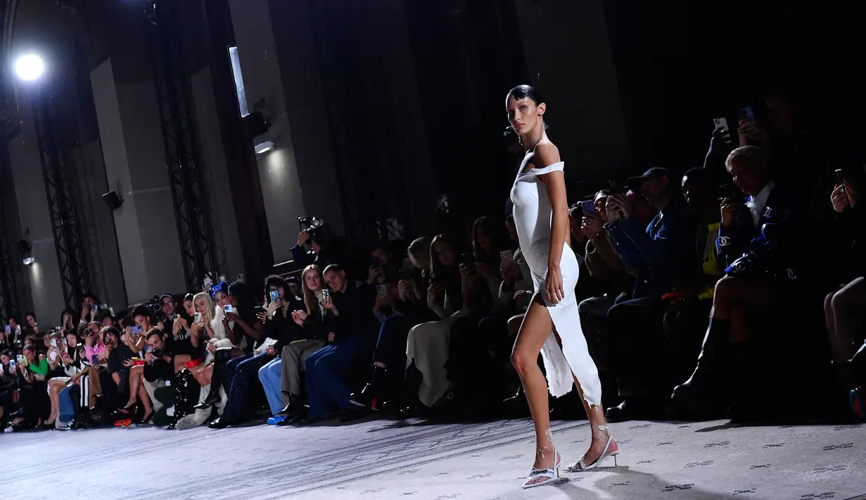 Model AS Bella Hadid menampilkan kreasi saat peragaan busana Coperni Spring-Summer 2023 pada Paris Fashion Week di Paris, Prancis, 30 September 2022. Gaun yang dikenakannya dapat dilepas dan diubah kembali menjadi larutan cair untuk digunakan ulang. (JULIEN DE ROSA/AFP)