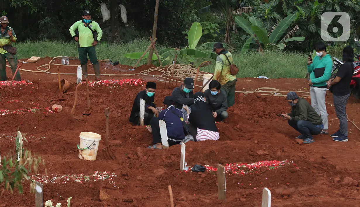Proses pemakaman jenazah dengan menerapkan protokol Covid-19 di TPU Pondok Ranggon, Jakarta Timur, Minggu (27/9/2020). Untuk tahap kedua, Dinas Bina Marga DKI Jakarta akan membuka lahan pemakaman baru seluas 6.150 meter persegi. (Liputan6.com/Herman Zakharia)