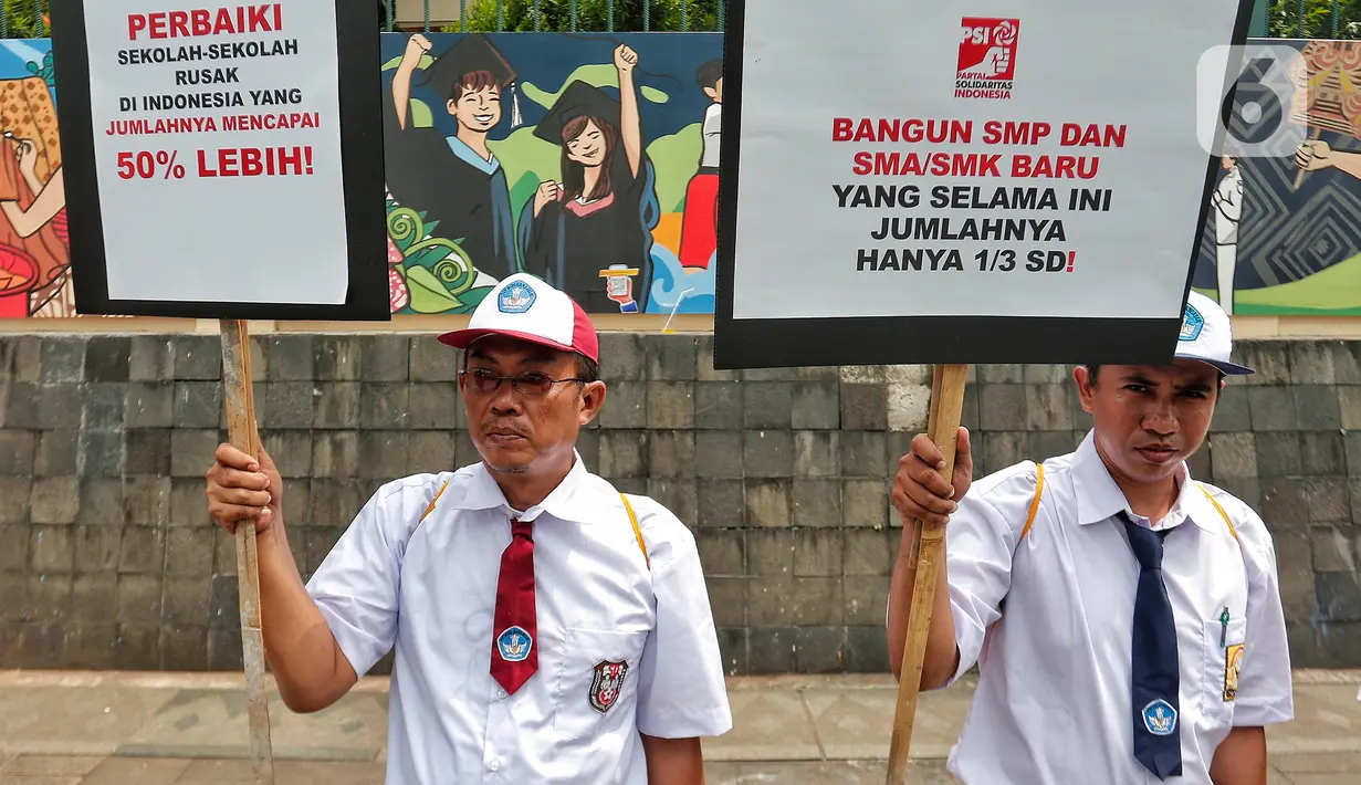Dua politikus Partai Solidaritas Indonesia (PSI) yang mengenakan seragam SD dan SMP menyuarakan pesan revolusi pendidikan saat menggelar aksi simpatik dan edukatif di depan Kantor Kemendikbudristek. (Liputan6.com/Angga Yuniar)