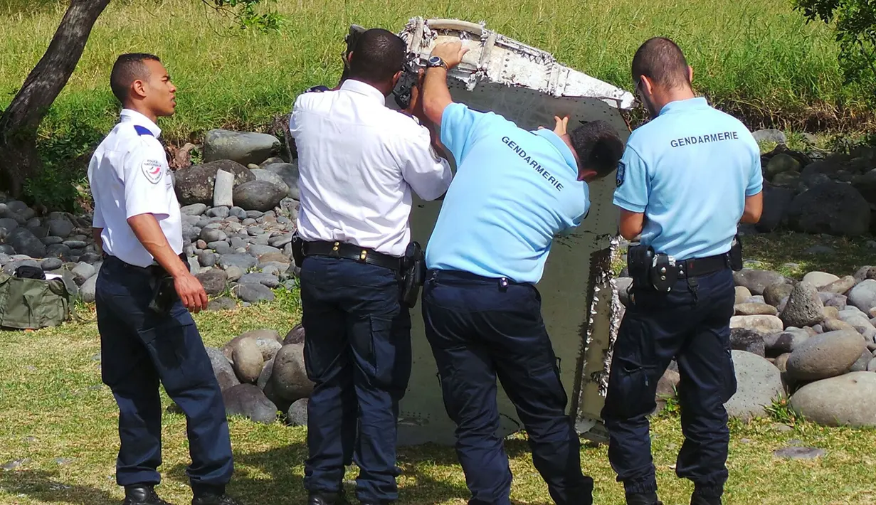 Polisi memeriksa potongan mirip badan pesawat yang diduga milik MH370 di pantai Saint - Andre, Perancis, Rabu (29/30/2015).  Diduga puing tersebut adalah potongan badan pesawat dari Malaysia Airlines MH370 yang hilang tahun lalu. (REUTERS/Prisca Bigot)
