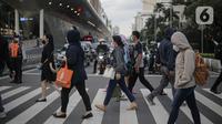 Pekerja kantoran menyebrang menggunakan fasilitas Pelican Crossing di kawasan Jalan Thamrin, Jakarta, Kamis (5/1/2023). Pencabutan Pemberlakuan Pembatasan Kegiatan Masyarakat (PPKM) dinilai untuk menggenjot ekonomi Indonesia 2023 yang diproyeksi suram akibat resesi global. (Liputan6.com/Faizal Fanani)