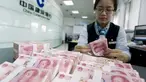Petugas menghitung lembaran 100 yuan di cabang China Construction Bank di Hai'an, provinsi Jiangsu, 10 Agustus 2015. Langkah Bank Sentral China menurunkan nilai tukar yuan terhadap dolar AS langsung membuat pelaku pasar ketakutan. (REUTERS/China Daily)