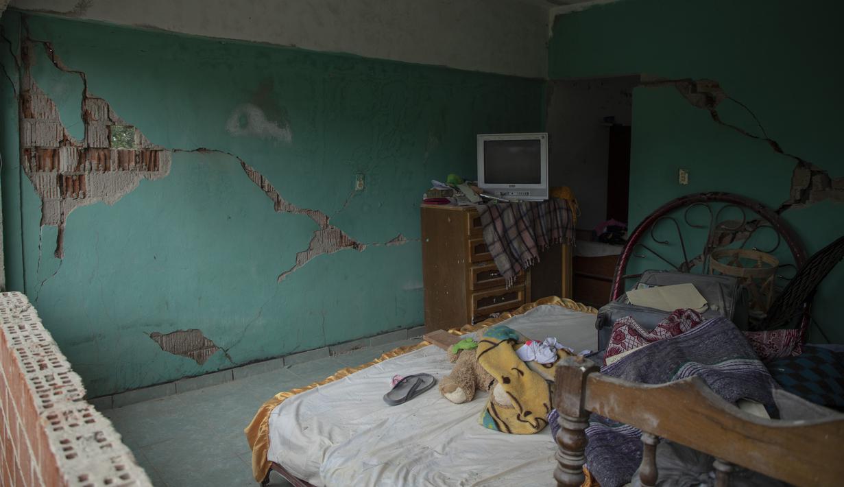 Dinding retak berdiri di sebuah rumah yang rusak akibat gempa bumi di Huizontla, negara bagian Michoacan, Meksiko, Selasa (20/9/2022). Gempa berkekuatan Magnitudo 7,6 mengguncang pantai Pasifik tengah Meksiko pada hari Senin waktu setempat. (AP Photo/Armando Solis)