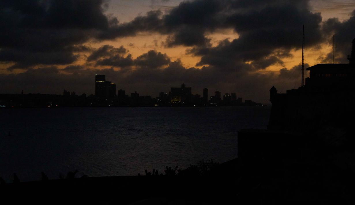 Pemadaman listrik terjadi setelah adanya kerusakan di pembangkit listrik termoelektrik Antonio Guiteras Power Plant, salah satu fasilitas pembangkit terbesar di negara tersebut. Kerusakan tersebut memicu runtuhnya sebagian sistem kelistrikan nasional, sehingga listrik padam di sebagian besar wilayah pulau. Tampa dalam foto, awan berkumpul di atas Havana selama pemadaman listrik, Kuba, Rabu 4 Maret 2026. (AP Photo/Ramon Espinosa)