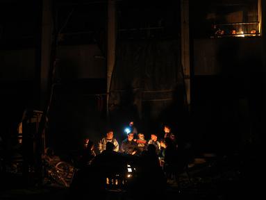 Warga Palestina duduk di dekat perapian di tengah reruntuhan rumah mereka di Jabalia di Jalur Gaza utara pada 18 Februari 2025. (Omar AL-QATTAA/AFP)