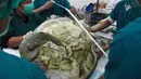 Petugas medis mempersiapkan operasi untuk penyu hijau betina di Fakultas Kedokteran Hewan, Thailand, Senin (6/3). Omsin menderita infeksi di bagian perut karena menelan ratusan koin yang dilemparkan pengunjung ke dalam kolam. (AP Photo/Sakchai Lalit)