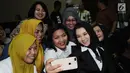 Bupati nonaktif Kutai Kartanegara, Rita Widyasari (kanan) berswafoto bersama kerabatnya jelang mengikuti sidang perdana di Pengadilan Tipikor, Jakarta, Rabu (21/2). Sidang mendengar dakwaan Jaksa Penuntut Umum. (Liputan6.com/Helmi Fithriansyah)