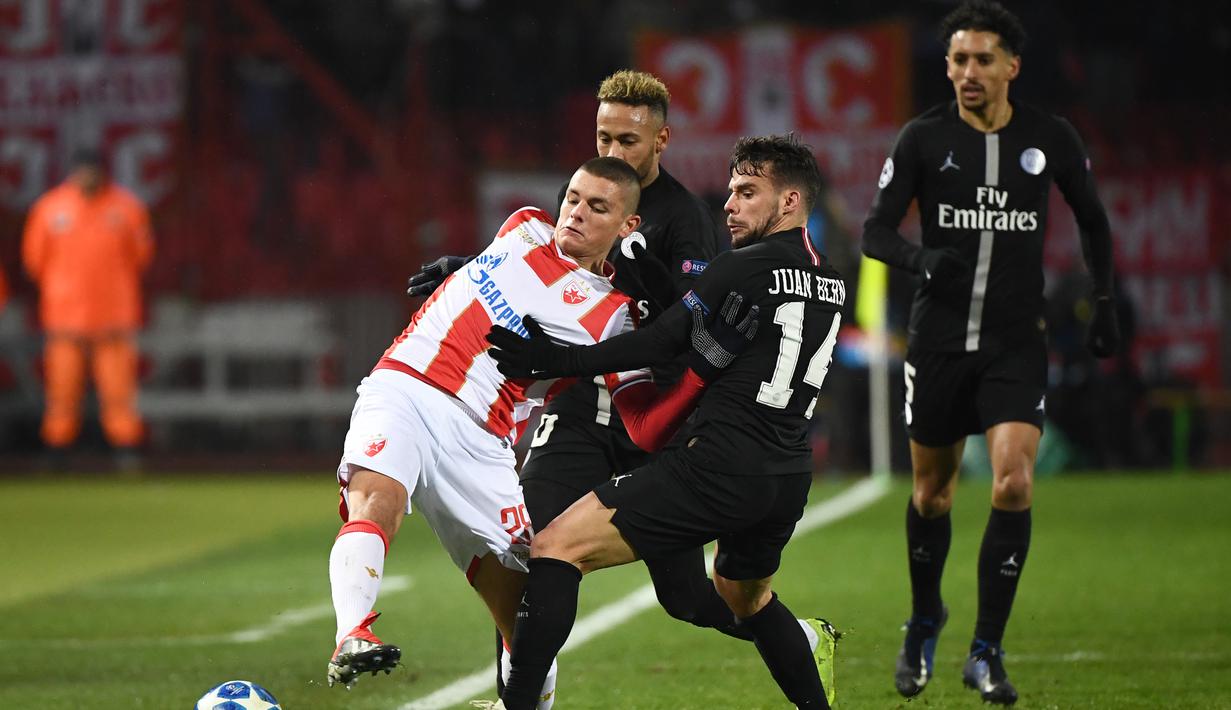 Aksi pemain PSG Juan Bernat menghalau pergerakan pemain Red Star Belgrade pada laga lanjutan Grup C Liga Champions yang berlangsung di stadion Rajko Mitic, Rabu (12/12). PSG menang 4-1 atas Red Star Belgrade. (AFP/Franck Fife)