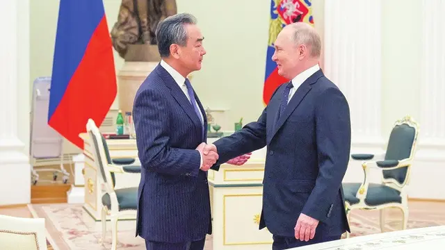Kepala Kebijakan Luar Negeri Partai Komunis China sekaligus diplomat paling senior negara itu, Wang Yi, saat bertemu dengan Presiden Rusia Vladimir Putin di Kremlin, Moskow, pada Rabu (22/2/2023).