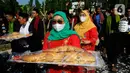 Warga membawa roti buaya saat pawai pada acara Lebaran Depok 2022 di Perumahan Shila Sawangan, Depok, Minggu (5/6/20222). Festival kebudayaan Lebaran Depok yang berlangsung 3 hari menampilkan berbagai  kegiatan pengenalan dan pelestarian budaya Kota Depok. (merdeka.com/Arie Basuki)