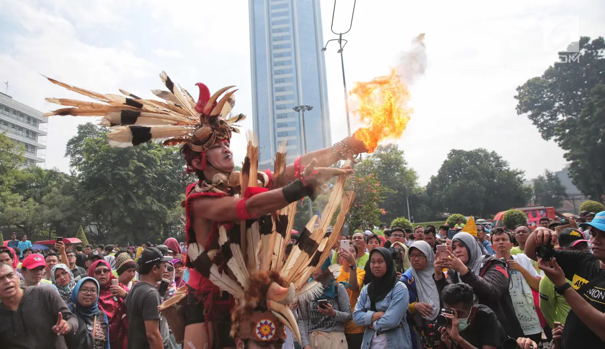 Atraksi budaya dayak meramaikan Car Free Day (CFD) di kawasan Sudirman, Jakarta, Minggu (29/10). Kegiatan Gelar Pesona Budaya Tabalong ini dilaksanakan kerukunan Keluarga Murung Pudak Tanjung Tabalong (KKMTT) di Jakarta. (Liputan6.com/Faizal Fanani)