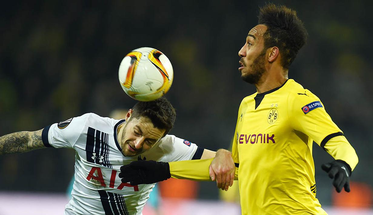 Striker Dortmund, Pierre Aubameyang duel udara dengan gelandang Tottenham, Ryan Mason. Takluk tiga gol tanpa balas ini membuat peluang Tottenham lolos semakin berat, mereka butuh kemenangan dengan selisih empat gol. (AFP/Patrik Stollarz)