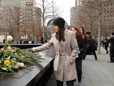 Orang-orang menaruh bunga mawar dalam peringatan 25 tahun serangan bom truk di WTC, New York City, Amerika Serikat, Senin (26/2). Serangan bom truk terjadi pada 26 Februari 1993. (Spencer Platt/Getty Images/AFP)