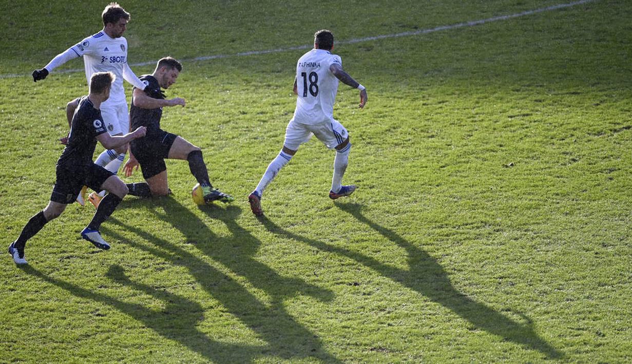 Striker Leeds United, Patrick Bamford, berebut bola dengan pemain Burnley, James Tarkowski, pada laga Liga Inggris di Stadion Elland Road, Minggu (27/12/2020). Leeds United menang dengan skor 1-0. (Laurence Griffiths/Pool via AP)