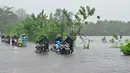 Departemen Meteorologi memperingatkan badai tersebut dapat menguat saat bergerak melintasi pulau itu dalam 12 jam ke depan. Tampak dalam foto, para pengendara berjalan di jalanan yang terendam banjir di Biyagama, pinggiran Kolombo, pada Jumat 28 November 2025. (Ishara S. KODIKARA/AFP)