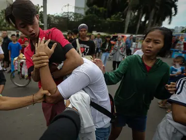Seorang pria dibekuk usai kepergok mencopet saat car free day di kawasan Bundaran HI, Jakarta, Minggu (15/1). Pria bernama Rio itu kepergok saat mengambil ponsel seorang pengunjung CFD. (Liputan6.com/Faizal Fanani)