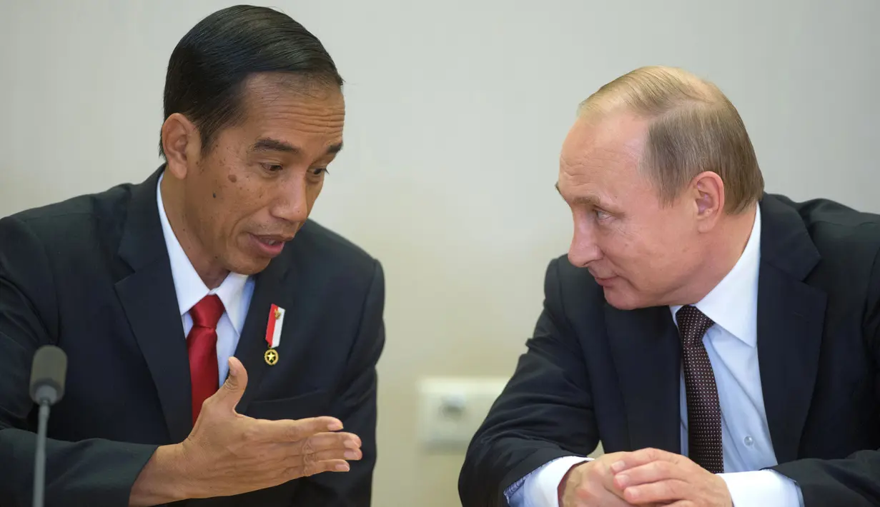 Presiden RI, Jokowi dan Presiden Rusia, Vladimir Putin (kanan) berbincang disela upacara penandatanganan seusai pertemuan di Sochi, Rusia, Rabu (18/5). Kedua pemimpin negara itu melakukan pertemuan bilateral sebelum KTT ASEAN-Rusia (Host Photo Agency/AFP)