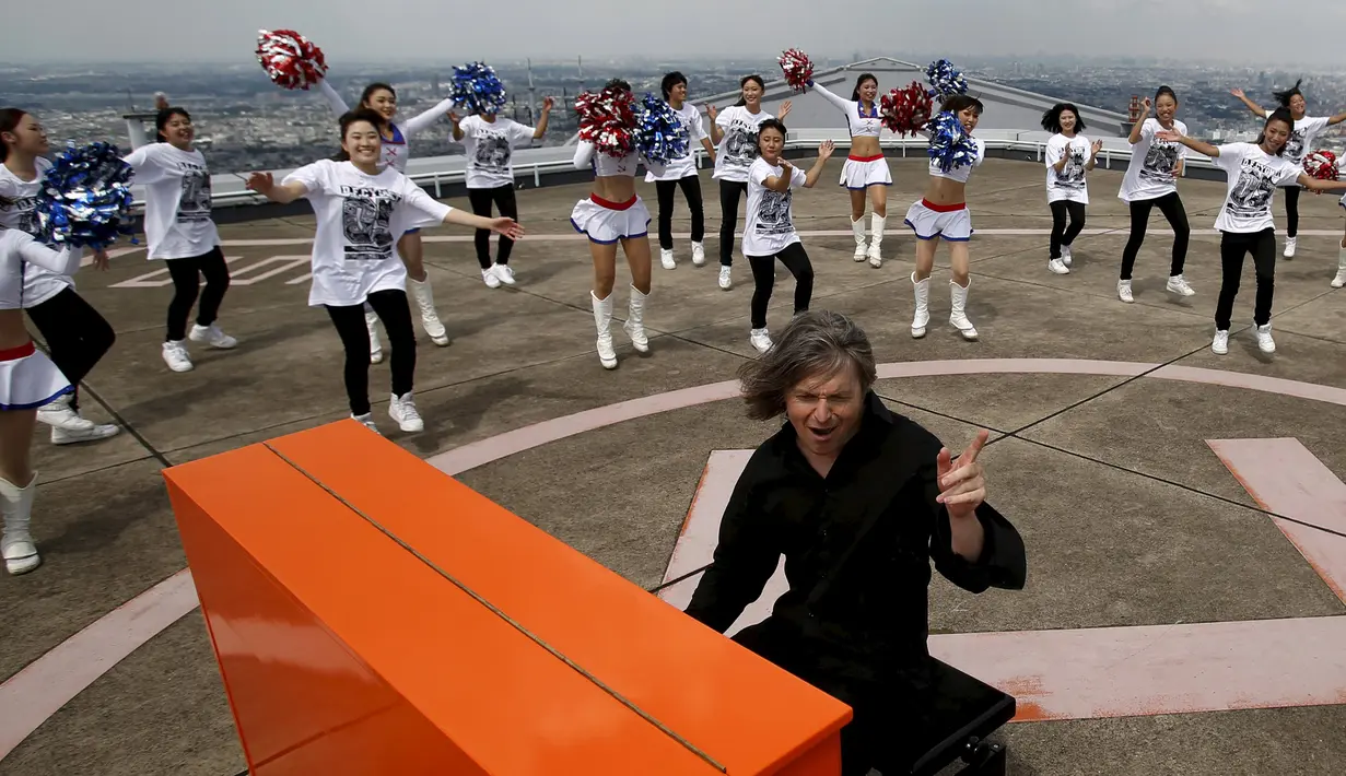 Stefan Aaron menggelar `Orange Piano Tour` di atas gedung Yokohama yang tingginya 296m, Jepang, Jumat (4/9/2015). Gedung Yokohama merupakan gedung tertinggi no 2 di Jepang.  Stefan main piano diiringi gadis cantik pemandu sorak (REUTERS/Yuya Shino)