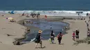 Orang-orang mengunjungi Pantai Baker selama masa pandemi covid-19 di San Francisco pada Minggu (24/5/2020). Warga Amerika Serikat mengabaikan pedoman jarak sosial dan memilih berjemur di pantai ketika angka kematian akibat virus corona di negara itu mendekati 100.000 orang. (AP/Jeff Chiu)