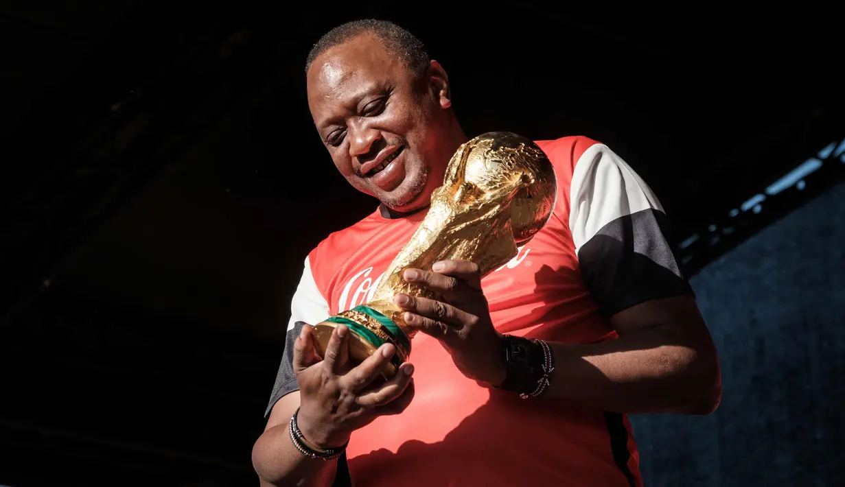Presiden Kenya Uhuru Kenyatta memegang trofi Piala Dunia FIFA saat Tur Dunia di Gedung Negara, Nairobi (26/2). Trofi ini terbuat dari emas murni 18 karat dengan dasar perunggu, setinggi 36,8 sentimeter dan berat 6,1 kilogram. (AFP Photo/Yasuyoshi Chiba)