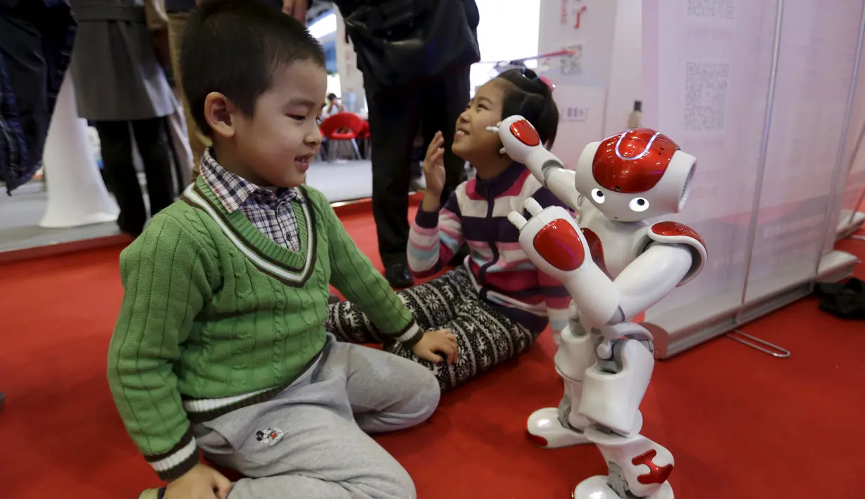 Robot bernama "Nao" buatan Aldebaran Robotics beraksi dengan berdansa selama acara Konferensi Robot Dunia di Beijing, Cina,  (24/11). Selain pameran robot, Acara ini juga mengadakan kontes robot bagi para pelajar dan pemuda. (REUTERS/Jason Lee)