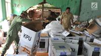 Petugas kecamatan menyelamatkan kotak suara kardus yang sebagian rusak terendam banjir di gudang tempat penyimpanan logistik di Kecamatan Ciseeng, Bogor, Senin (15/4). Lebih dari 600 kotak suara rusak akibat tembok gudang jebol diterpa hujan lebat dan angin kencang semalam. (merdeka.com/Arie Basuki)