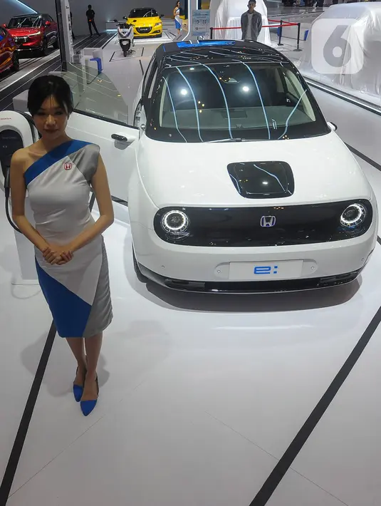 SPG berdiri di depan mobil listrik Honda e yang dipamerkan pada pameran otomotif Gaikindo Indonesia International Auto Show (GIIAS) 2023 di ICE BSD, Tangerang, Banten, Kamis (10/8/2023). (merdeka.com/Arie Basuki)