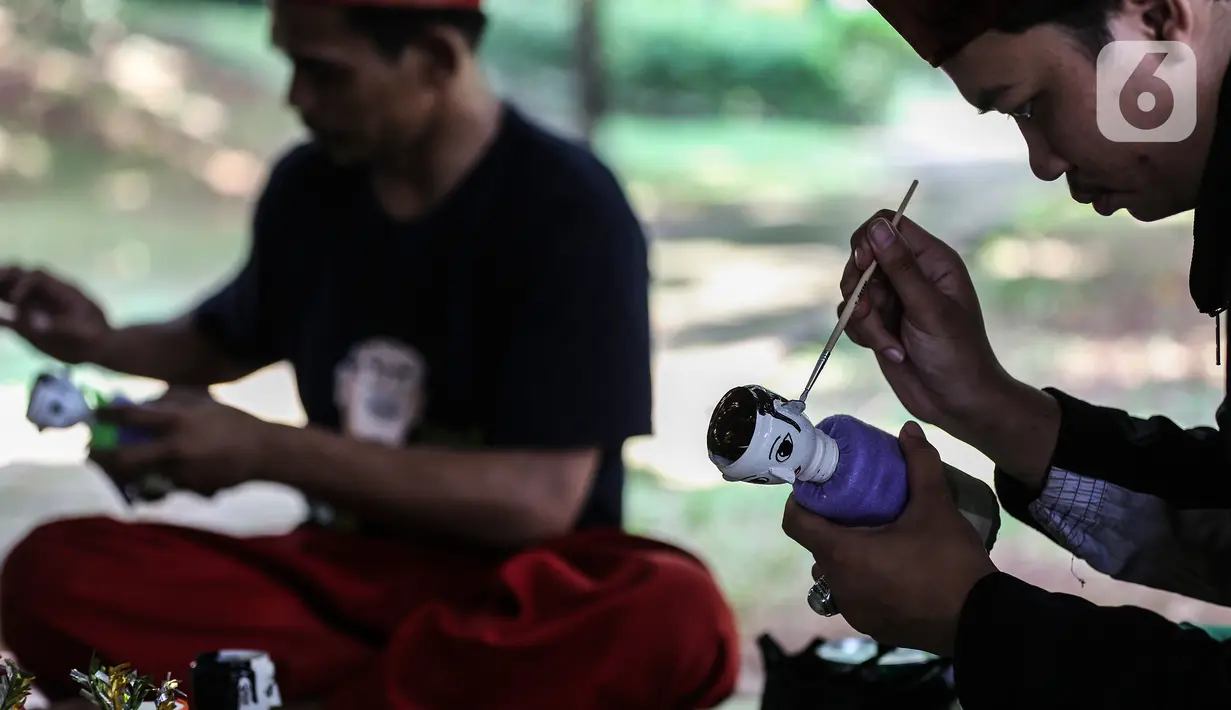Chairuddin (40) bersama rekannya mewarnai ondel-ondel dari botol bekas di Sanggar Rumah Kreasi, Jakarta, Minggu (13/6/2021). Chairuddin memanfaatkan botol bekas menjadi ondel-ondel untuk dijual dengan harga sepasang Rp35 ribu dan bisa membuat ratusan setiap harinya. (Liputan6.com/Johan Tallo)