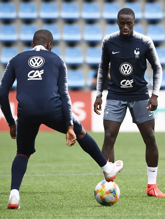 Bek Prancis, Ferland Mendy (kanan) berusaha merebut bola saat mengikuti latihan di Andorra La Vella (10/6/2019). Prancis akan bertanding melawan timnas Andorra pada grup H Kualifikasi Piala Eropa 2020 di Estadi Nacional d'Andorra. (AFP Photo/Franck Fife)