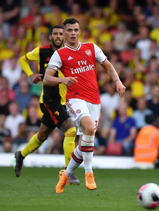 Gelandang Arsenal, Granit Xhaka berusaha mengontrol bola dibayangi pemain Watford pada pekan kelima Liga Inggris 2019-2020 di Vicarage Road, Minggu (15/9/2019). Sempat unggul dua gol, Arsenal harus rela imbang 2-2 saat berjumpa tim tuan rumah Watford. (Ben STANSALL / AFP)