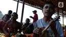 Seorang anak memainkan alat musik saat mengikuti latihan tari di rumah seni Sawinggrai, Raja Ampat, Papua Barat, Jumat (22/11/2019). Pertamina melalui program tanggung jawab sosialnya membangun Rumah Seni Budaya Sawinggrai pada tahun 2016. (Liputan6.com/Herman Zakharia)