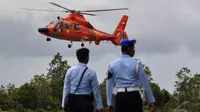 Dua personil TNI AU bersiaga jelang mendarat helikopter yang membawa jenazah korban pesawat AirAsia QZ8501 di Lanud Iskandar, Pangkalan Bun, Kalteng, Rabu (31/12/2014). (Liputan6.com/Miftahul Hayat)