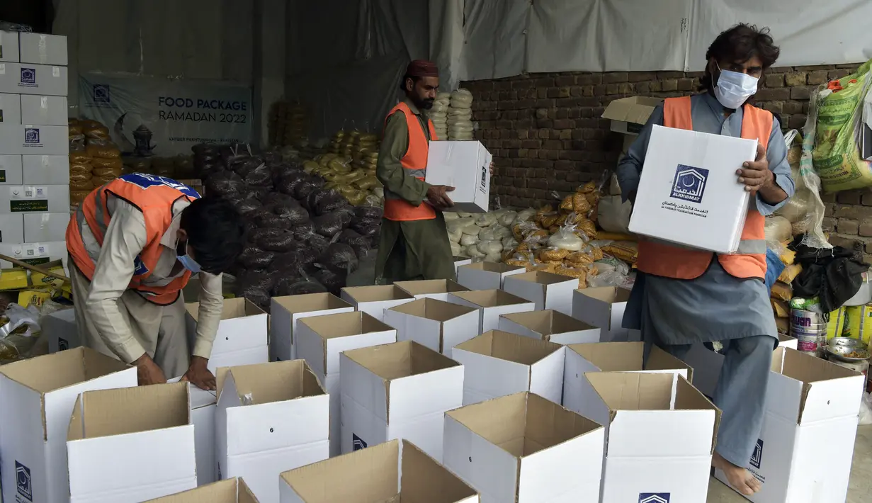 Aktivis Yayasan Al khidmat Pakistan, sebuah organisasi nirlaba, mengemas makanan berbuka puasa untuk dikirim ke Afghanistan jelang awal bulan suci Ramadhan di Peshawar, Pakistan, 23 Maret 2022. (Abdul MAJEED/AFP)