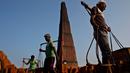 Para pekerja India membawa batu bata di pundak mereka di pabrik pembuatan batu bata di pinggiran Gauhati, India (22/11). Mereka menghasilkan 120 Rupee (kurang dari 2 Dolar) per hari. (AP Photo/Anupam Nath)