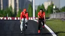Pembalap Monegasque Ferrari, Charles Leclerc (kiri) bersepeda di Sirkuit Shanghai International pada 18 April 2024. (Pedro PARDO/AFP)