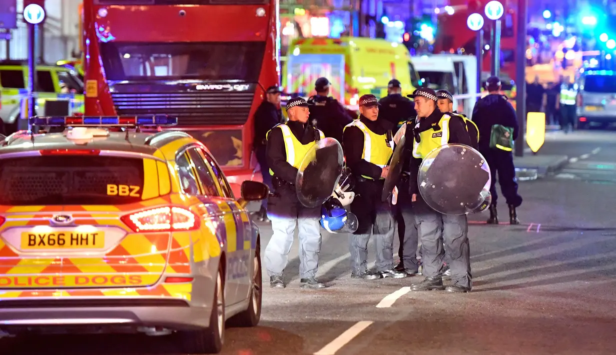 Polisi dengan perisai anti huru hara di Borough High Street setelah teror di London tengah, Sabtu (3/6). Serangan teror terjadi di London Bridge dan Borough Market, yang dilakukan lima orang pria. (AP Photo/ Matt Dunham). (Dominic Lipinski/PA via AP)