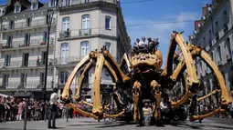 Laba-laba raksasa Kumo Ni menghebohkan warga saat berjalan keliling Kota Nantes, Prancis, Jumat (8/7). Butuh lebih dari 10 orang untuk menggerakkan kaki laba-laba buatan perusahaan La Machine tersebut. (REUTERS/Stephane Mahe)