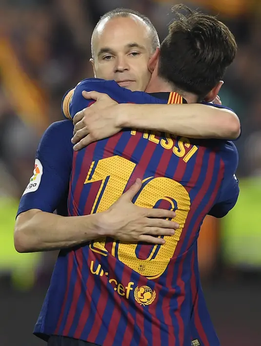 Gelandang Barcelona, Andres Iniesta, memuluk Lionel Messi saat melawan Real Sociedad pada laga La Liga Spanyol di Stadion Camp Nou, Barcelona, Minggu (20/5/2018). Dirinya berpisah dengan klub yang 22 tahun telah dibela. (AFP/Lluis Gene)