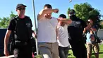Dua dari 8 perwira militer pendukung kudeta di Turki dikawal polisi Yunani di kota Alexandroupoli, Minggu (17/7). 8 pria yang terbang dengan helikopter militer Turki itu ditahan petugas keamanan Yunani karena masuk secara ilegal. (Sakis MITROLIDIS/AFP)