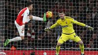Gelandang Arsenal, Mesut Ozil (kiri), mencoba menaklukkan gawang Southampton yang dikawal Frazier Forster (kanan), pada laga Premier League di Emirates, London, Rabu (3/2/2016) dini hari WIB. (AFP/Justin Tallis)