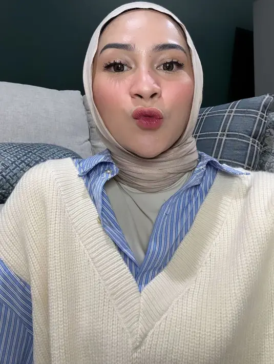 Sedangkan, Ira Nandha mengenakan inner manset abu-abu dipadukan kemeja lengan panjang biru serta outer vest putih knit serta kerudung coklat. [@iranndha]