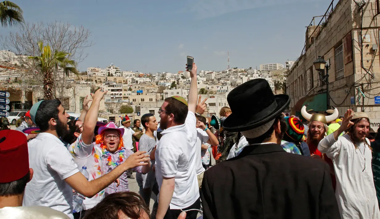 Suasana saat warga Yahudi merayakan Hari Purim di Jalan al-Shuhada, Kota Hebron, Tepi Barat, Kamis (1/3). (AFP PHOTO/HAZEM BADER)