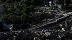 Seorang pekerja membawa balok kayu selama operasi pembongkaran kota kumuh distrik "Talus 2" di Koungou, di pulau Mayotte, Samudra Hindia Prancis, pada 23 Mei 2023. (AFP/PHILIPPE LOPEZ)