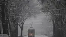 Sebuah trem melaju di tengah salju di Milan, Italia (28/12/2020). Sekitar 20 sentimeter salju turun di kota itu, di mana seorang pria tunawisma berusia 76 tahun meninggal di rumah sakit setelah ditemukan di jalan. (Xinhua/Daniele Mascolo)