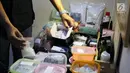 Petugas menunjukkan barang bukti narkotika jenis sabu dan pil ekstasi di sebuah perumahan di Kawasan Pondok Rajeg, Cibinong, Jawa Barat, Senin (24/9). Polisi juga menahan tiga tersangka dan sejumlah barang bukti terkait. (Liputan6.com/Helmi Fithriansyah)