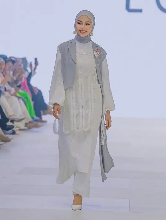 Tampil serba putih dengan atasan tunik berbordir lengan panjang dipadukan celana panjang. Agar lebih stylish bisa padukan vest crop top warna biru yang serasi dengan kerudungnya. [@daraarafah]