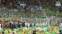 Ribuan muslimat menghadiri Harlah ke-73 Muslimat NU di Stadion Utama GBK, Jakarta, Minggu (27/1). Guyuran hujan tidak menyurutkan semangat anggota Muslimat NU untuk mengikuti dan memeriahkan acara yang dihadiri Presiden Jokowi. (Liputan6.com/Johan Tallo)