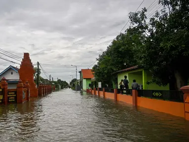 Sebuah jalan yang tergenang air akibat luapan sungai terlihat setelah hujan lebat di desa Tempuran, Mojokerto, Jawa Timur, pada 9 Desember 2024. (Juni KRISWANTO/AFP)