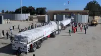 Orang-orang di perbatasan Rafah sisi Mesir bersorak saat konvoi truk yang membawa bantuan kemanusiaan melintasi Jalur Gaza, Sabtu (21/10/2023). (Mohammed Assad / AFP)
